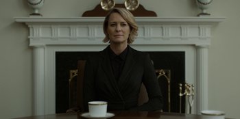 Movie still from “House of Cards” (2013), created by Beau Willimon – A woman sitting at a table with a cup of coffee in front of her; Medium shot, Low angle