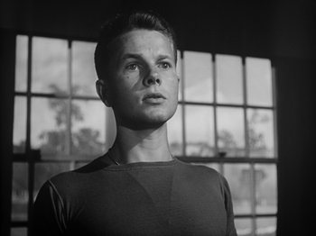 Movie still from “Twelve O'Clock High” (1949), directed by Henry King – Black and white photograph of a young man in front of a window; Close Up shot, Low angle