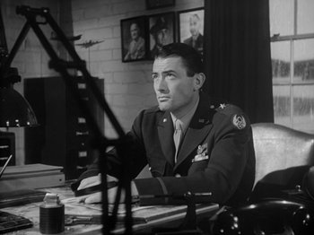 Movie still from “Twelve O'Clock High” (1949), directed by Henry King – A man sitting at a desk in a room; Medium shot, Low angle