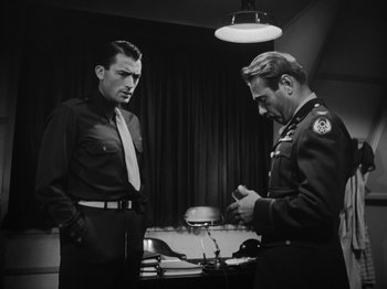 Movie still from “Twelve O'Clock High” (1949), directed by Henry King – Two men standing next to each other in front of a table; Medium shot, Low angle