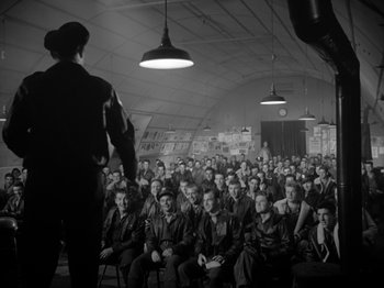 Movie still from “Twelve O'Clock High” (1949), directed by Henry King – A man standing in front of a crowd of people; Wide shot, High angle
