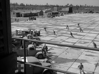 Movie still from “Twelve O'Clock High” (1949), directed by Henry King – A black and white photo of men working in a field; Extreme Wide shot, High angle