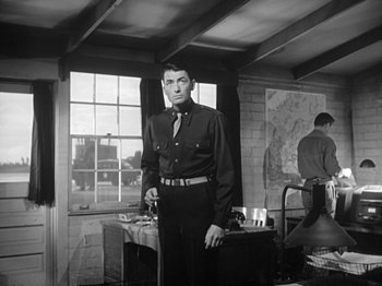 Movie still from “Twelve O'Clock High” (1949), directed by Henry King – Black and white photograph of a man standing in a room; Medium shot, Low angle