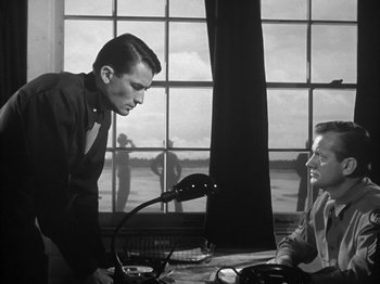 Movie still from “Twelve O'Clock High” (1949), directed by Henry King – A man standing next to another man in front of a window; Medium shot, Over the shoulder angle