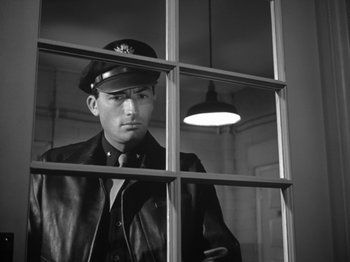 Movie still from “Twelve O'Clock High” (1949), directed by Henry King – A black and white photo of a man wearing a hat; Medium shot, Low angle