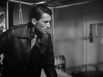 Movie still from “Twelve O'Clock High” (1949), directed by Henry King – A black and white photo of a man wearing a leather jacket; Medium shot, Over the shoulder angle