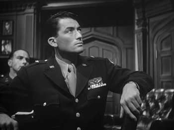Movie still from “Twelve O'Clock High” (1949), directed by Henry King – A man in a military uniform looking at something on the wall; Medium shot, Low angle