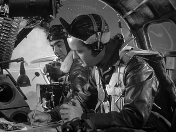 Movie still from “Twelve O'Clock High” (1949), directed by Henry King – Two men are sitting in the cockpit of an airplane; Medium shot, Low angle