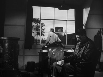 Movie still from “Twelve O'Clock High” (1949), directed by Henry King – A man sitting in a barber chair in front of a window; Wide shot, Low angle