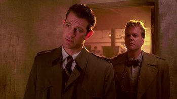 Movie still from “Twin Peaks: Fire Walk with Me” (1992), directed by David Lynch – A man in a suit standing next to another man in a tie; Close Up shot, Over the shoulder angle