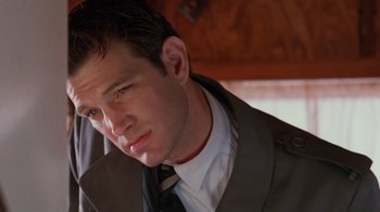 Movie still from “Twin Peaks: Fire Walk with Me” (1992), directed by David Lynch – A person wearing a suit and tie; Close Up shot, Low angle