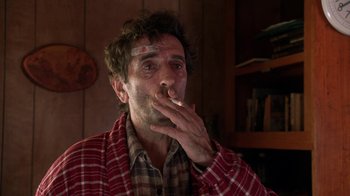 Movie still from “Twin Peaks: Fire Walk with Me” (1992), directed by David Lynch – A man smoking a cigarette while wearing a plaid shirt; Close Up shot, Low angle