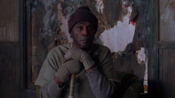 Movie still from “Twin Peaks: Fire Walk with Me” (1992), directed by David Lynch – A man in a hat and gloves holding a cane; Medium shot, Low angle