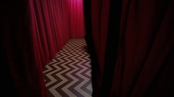 Movie still from “Twin Peaks: Fire Walk with Me” (1992), directed by David Lynch – A room with red drapes on the walls and a black and white striped floor; Extreme Wide shot, High angle