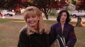 Movie still from “Twin Peaks: Fire Walk with Me” (1992), directed by David Lynch – Two women are standing in a park holding books; Medium shot, Over the shoulder angle