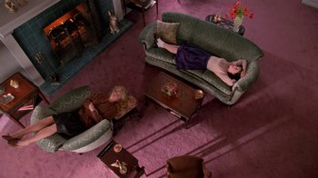 Movie still from “Twin Peaks: Fire Walk with Me” (1992), directed by David Lynch – A man and a woman laying on a couch in a living room; Wide shot, Overhead angle