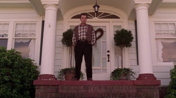 Movie still from “Twin Peaks: Fire Walk with Me” (1992), directed by David Lynch – A man standing on the front steps of a house; Wide shot, Low angle