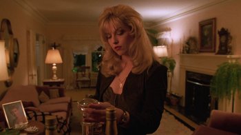 Movie still from “Twin Peaks: Fire Walk with Me” (1992), directed by David Lynch – A woman in a black jacket is looking at her cell phone; Medium shot, Low angle