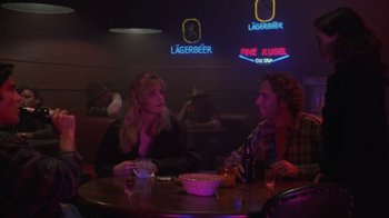 Movie still from “Twin Peaks: Fire Walk with Me” (1992), directed by David Lynch – A man and a woman sitting at a table in front of neon signs; Medium shot, Over the shoulder angle