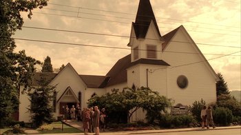 Movie still from “Twin Peaks: Fire Walk with Me” (1992), directed by David Lynch – A group of people standing in front of a church; Extreme Wide shot, Low angle