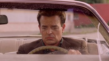 Movie still from “Twin Peaks: Fire Walk with Me” (1992), directed by David Lynch – A man sitting in the drivers seat of a car; Close Up shot, Low angle