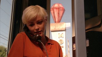 Movie still from “Twin Peaks: Fire Walk with Me” (1992), directed by David Lynch – A woman in an orange shirt talking on a phone; Close Up shot, Low angle