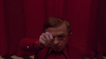 Movie still from “Twin Peaks: Fire Walk with Me” (1992), directed by David Lynch – A man in a red shirt is holding a green ring; Close Up shot, High angle