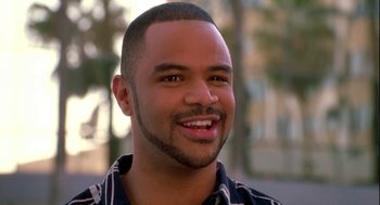 Movie still from “Two Can Play That Game” (2001), directed by Mark Brown – A person smiling for the camera; Close Up shot, Low angle