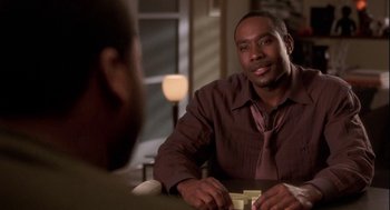 Movie still from “Two Can Play That Game” (2001), directed by Mark Brown – A man sitting at a table in front of another man; Close Up shot, Over the shoulder angle