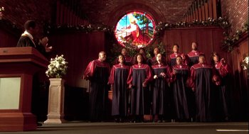 Movie still from “Two Can Play That Game” (2001), directed by Mark Brown – A group of people standing next to each other in front of a stained glass window; Wide shot, High angle