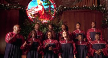 Movie still from “Two Can Play That Game” (2001), directed by Mark Brown – A group of people singing in front of a stained - glass window; Medium shot, High angle
