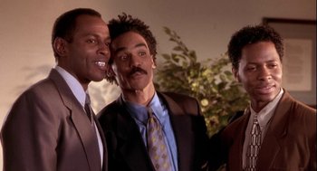 Movie still from “Two Can Play That Game” (2001), directed by Mark Brown – A group of men standing next to each other in a room; Close Up shot, Low angle