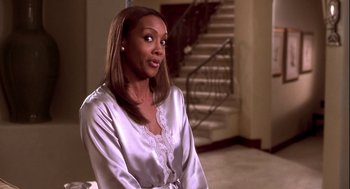 Movie still from “Two Can Play That Game” (2001), directed by Mark Brown – A woman sitting down in front of a staircase; Medium shot, Over the shoulder angle