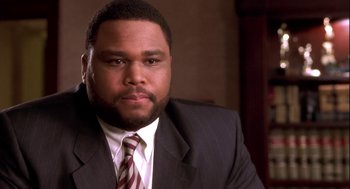 Movie still from “Two Can Play That Game” (2001), directed by Mark Brown – A man wearing a suit and tie in front of a window; Close Up shot, Low angle
