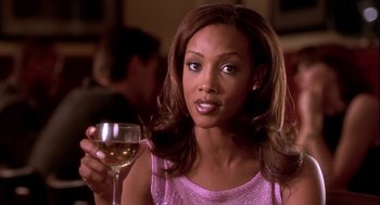 Movie still from “Two Can Play That Game” (2001), directed by Mark Brown – A woman holding a glass of wine in her right hand; Close Up shot, Over the shoulder angle