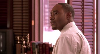 Movie still from “Two Can Play That Game” (2001), directed by Mark Brown – A man in a white dress shirt is looking out a window; Close Up shot, Over the shoulder angle