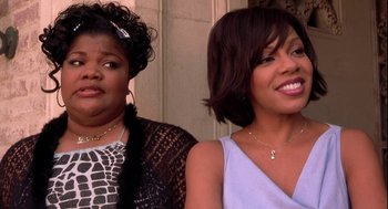 Movie still from “Two Can Play That Game” (2001), directed by Mark Brown – Two women standing next to each other in front of a building; Close Up shot, Over the shoulder angle