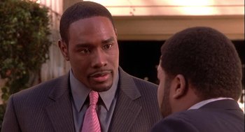 Movie still from “Two Can Play That Game” (2001), directed by Mark Brown – A man wearing a suit and a pink neck tie; Close Up shot, Over the shoulder angle