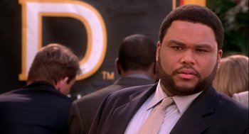 Movie still from “Two Can Play That Game” (2001), directed by Mark Brown – A man in a suit and tie standing in front of other men; Close Up shot, Low angle