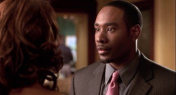 Movie still from “Two Can Play That Game” (2001), directed by Mark Brown – A person wearing a suit and tie; Close Up shot, Over the shoulder angle