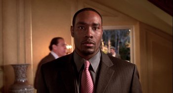 Movie still from “Two Can Play That Game” (2001), directed by Mark Brown – A man wearing a suit and tie standing in a room; Close Up shot, Low angle