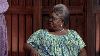 Movie still from “Madea on the Run” (2017), directed by Derrick Doose – An older woman wearing a green and blue dress; Close Up shot, Over the shoulder angle