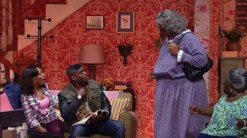 Movie still from “Madea on the Run” (2017), directed by Derrick Doose – A man sitting on top of a couch next to an older woman; Wide shot, Over the shoulder angle