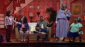 Movie still from “Madea on the Run” (2017), directed by Derrick Doose – A group of people sitting on a couch on a stage; Wide shot, High angle