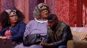 Movie still from “Madea on the Run” (2017), directed by Derrick Doose – A man and a woman sitting next to each other on a couch; Medium shot, Over the shoulder angle