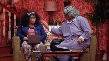 Movie still from “Madea on the Run” (2017), directed by Derrick Doose – Two women sitting on a couch in a living room; Medium shot, Over the shoulder angle