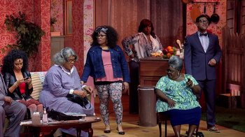 Movie still from “Madea on the Run” (2017), directed by Derrick Doose – A group of people sitting on top of a wooden floor; Wide shot, Over the shoulder angle