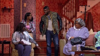 Movie still from “Madea on the Run” (2017), directed by Derrick Doose – A group of people sitting around a living room; Wide shot, Over the shoulder angle