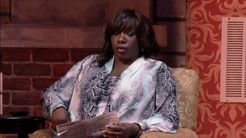 Movie still from “Madea on the Run” (2017), directed by Derrick Doose – A woman sitting on top of a couch holding a newspaper; Medium shot, High angle