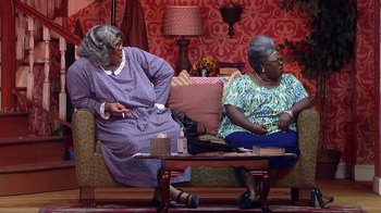 Movie still from “Madea on the Run” (2017), directed by Derrick Doose – Two older women sitting on a couch in a living room; Wide shot, High angle